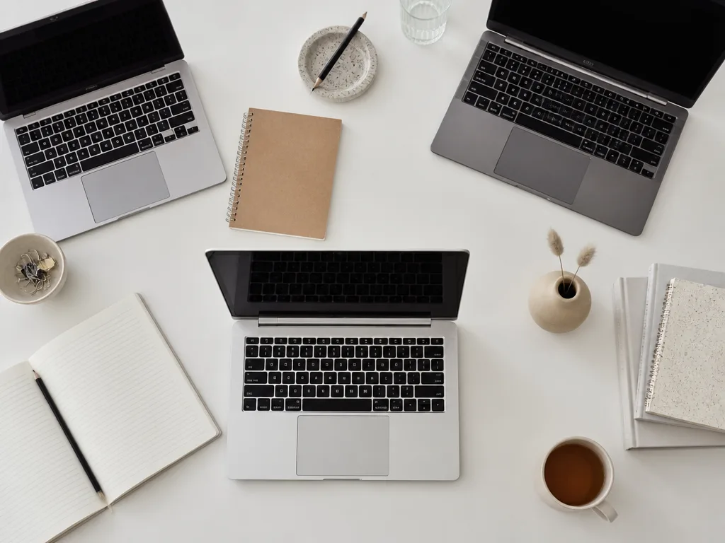 Flera tunna budgetlaptops öppna på ett minimalistiskt skrivbord — köpguide laptop bäst i test budget 2026
